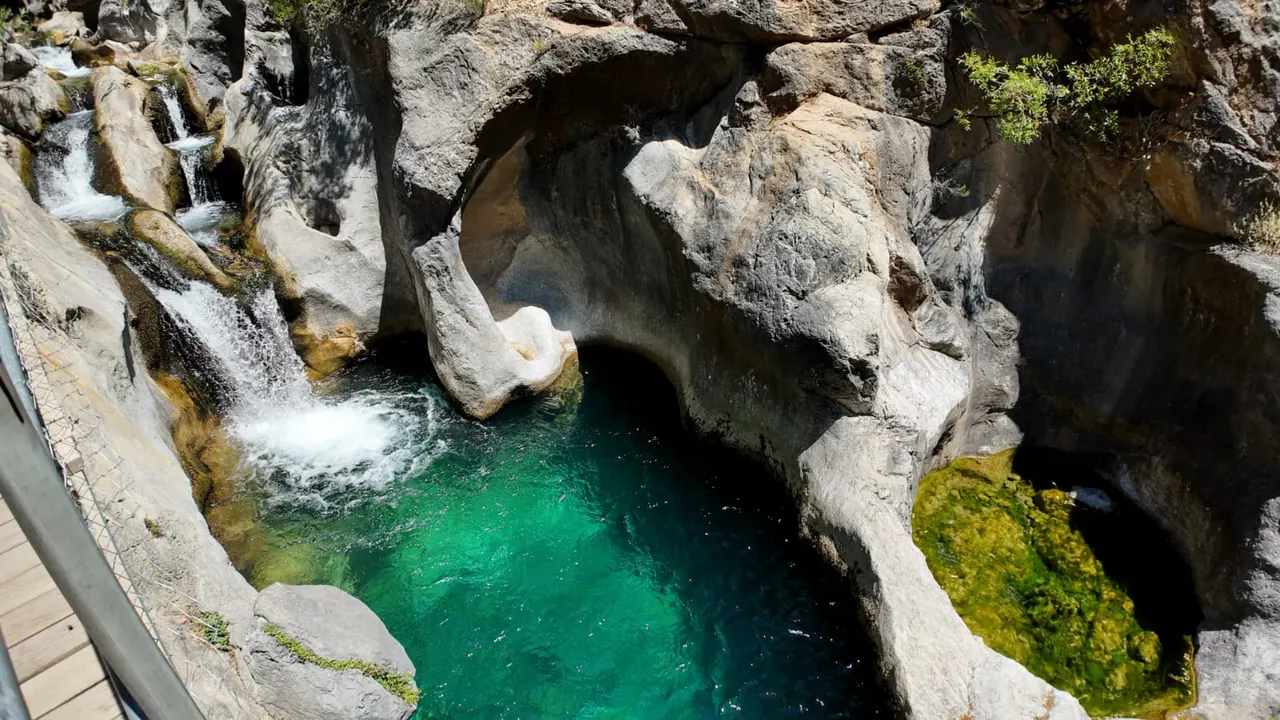 Un bassin vert émeraude alimenté par des cascades, sous une roche calcaire lisse, dans le canyon de Sapadere